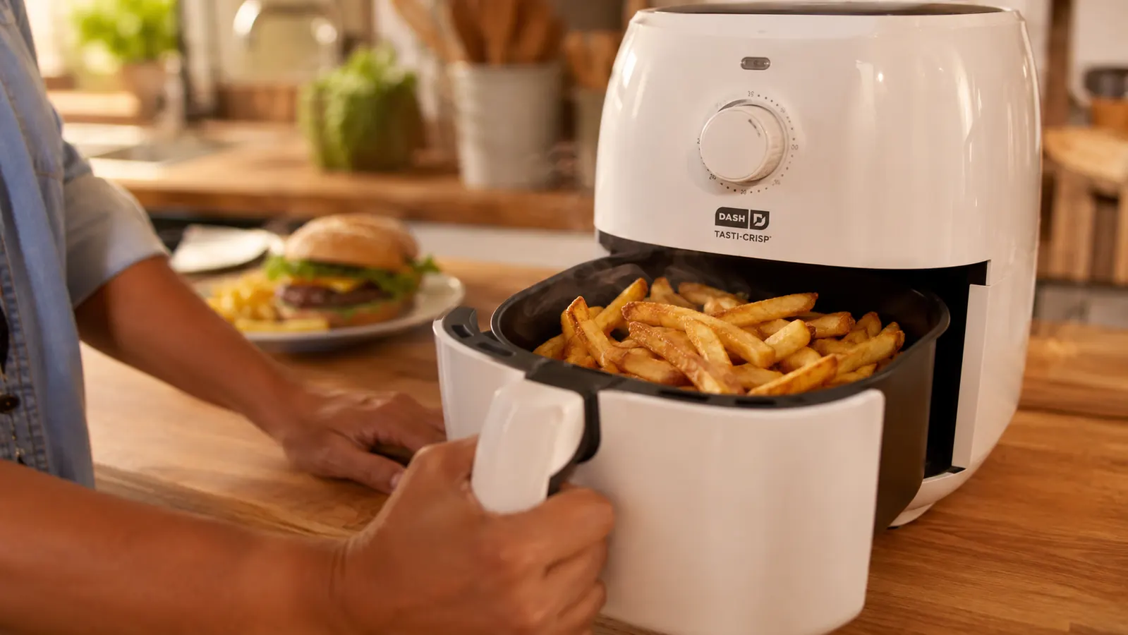 Golden crispy french fries in an air fryer basket after cooking
