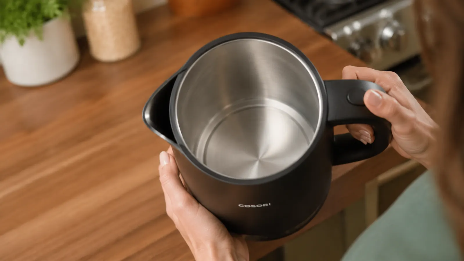 Inside view of the Cosori kettle's stainless steel interior showing the flat heating disc at the base and no visible plastic