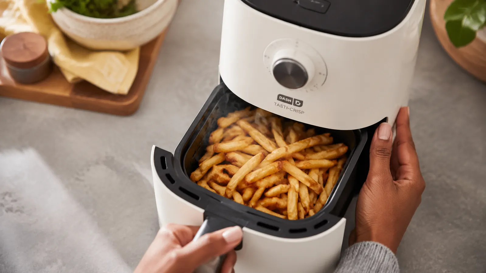 Golden crispy frozen fries in a small air fryer basket fresh out of cooking