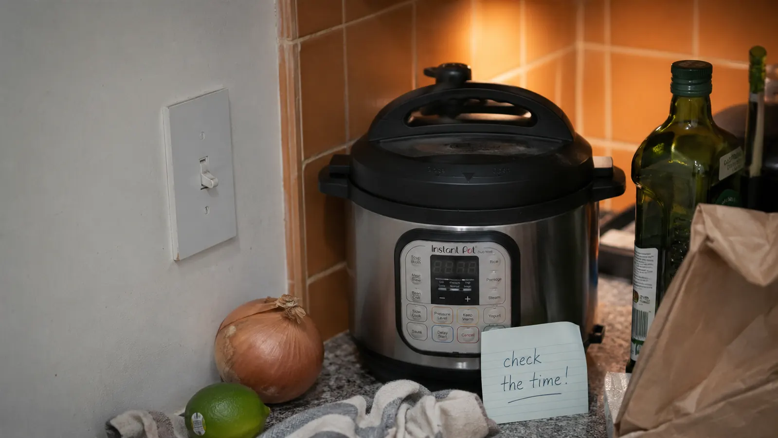 Instant Pot Duo Mini 3-quart on a small kitchen counter with a cautionary sticky note on the lid