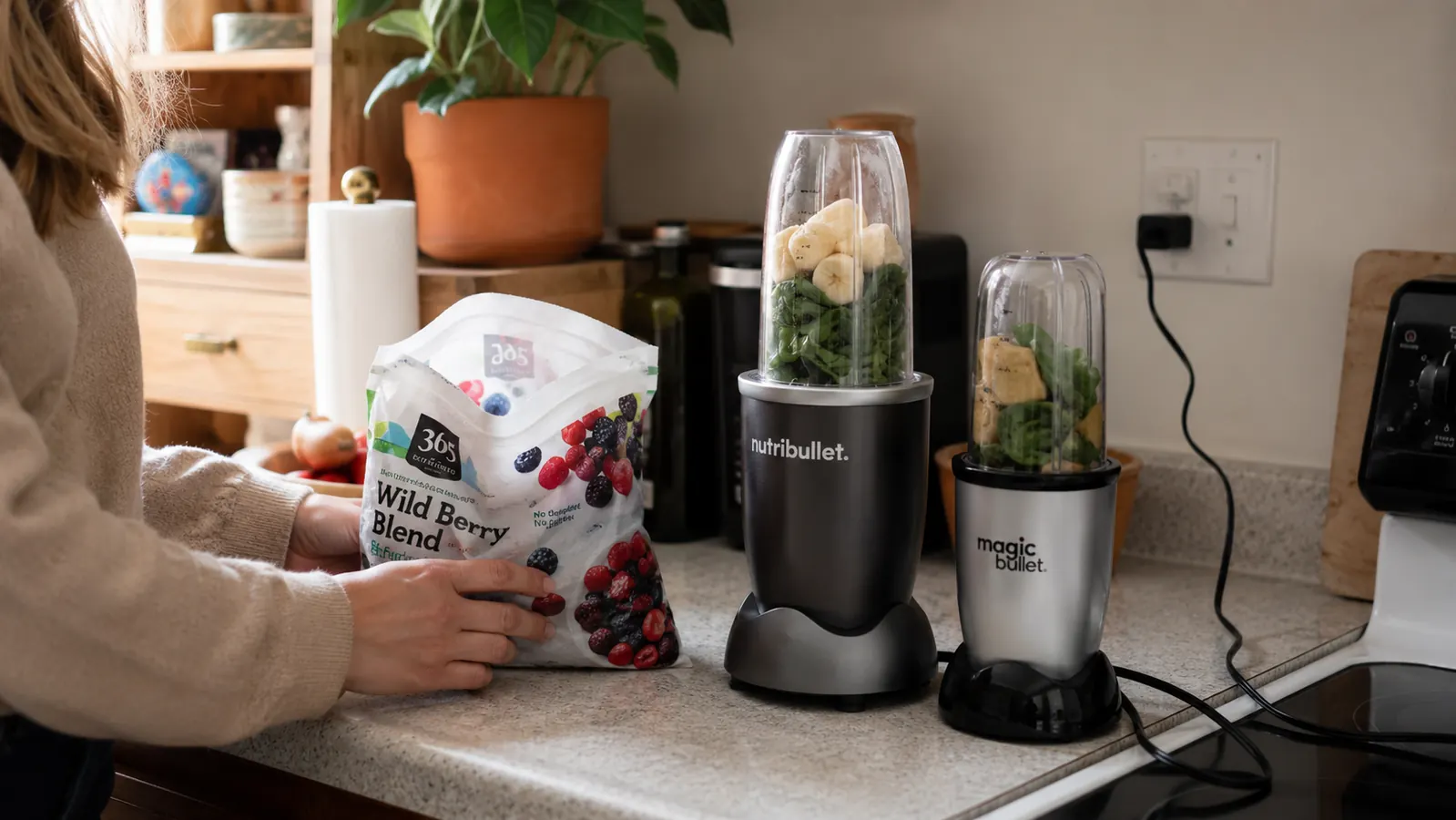 NutriBullet 600W blender on a small kitchen counter beside a Magic Bullet and a bag of frozen fruit, comparison setup