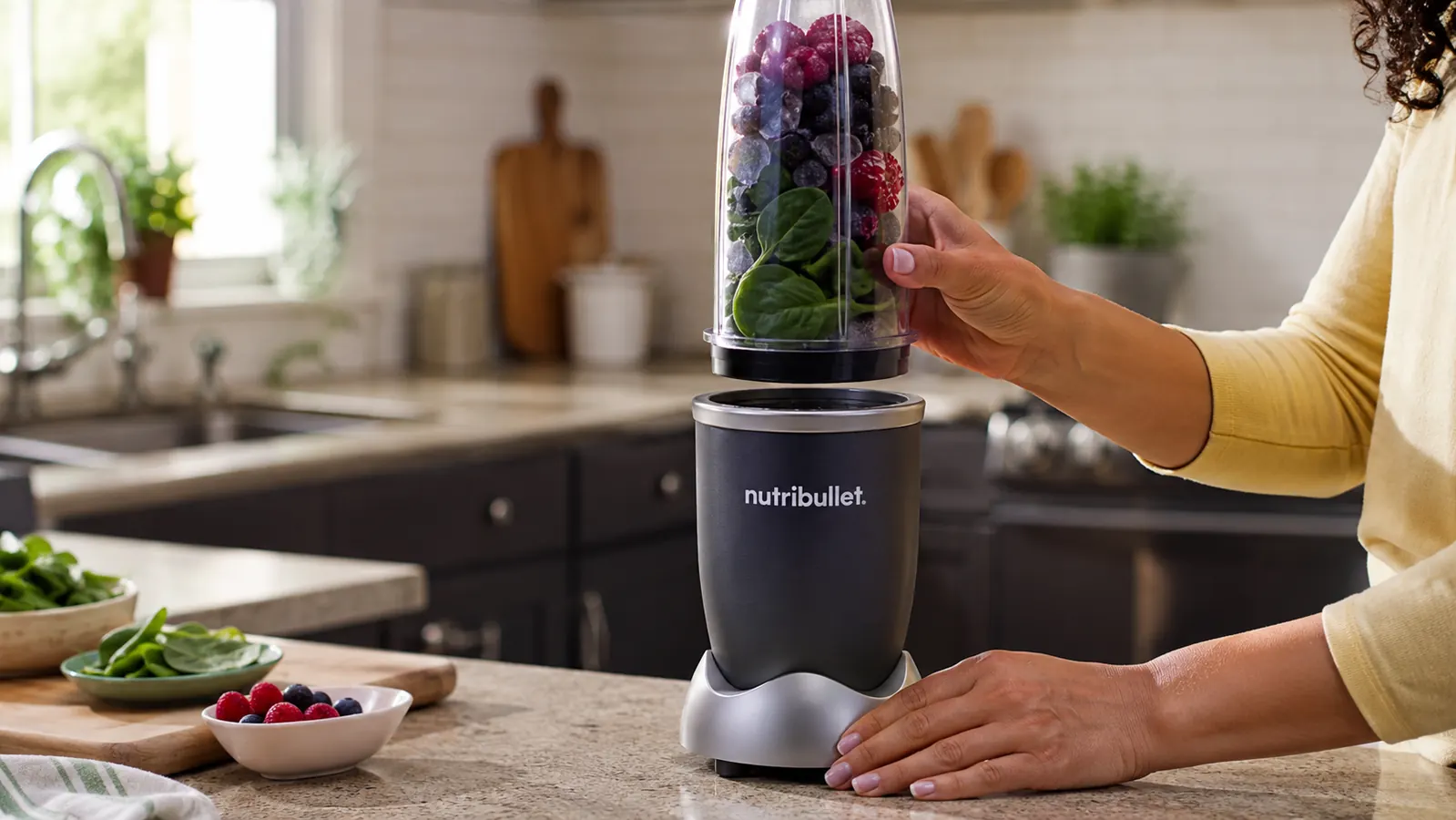 Close-up of a NutriBullet 600W cup filled with frozen fruit and spinach, ready to blend